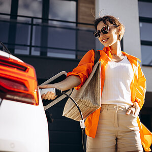 THG-Quote verkaufen. Frau lädt E-Auto