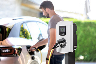 Firmenwagen zuhause laden Abrechnung, Mann lädt Elektro Dienstwagen zuhause.