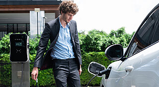 E-Mobilität Unternehmen. Mann lädt E-Auto an Wallbox