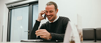 Karriere im Vertrieb bei Westfalen. Mann telefoniert bei der Arbeit