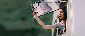 Wohnmobil. Frau am Fenster von einem Wohnmobil 