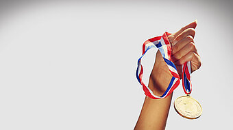 Qualität und Sicherheit bei Gasen und Energie von Westfalen. Hand hält Medaille