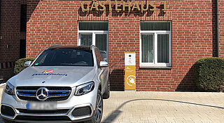 Ladeinfrastruktur für Unternehmen. E-Auto an Wallbox vor Hotel Clemens August