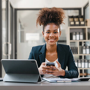 Westfalen Card. Frau sitzt an Handy und Computer