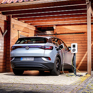 Firmenwagen zuhause laden. E-Auto lädt im Carport
